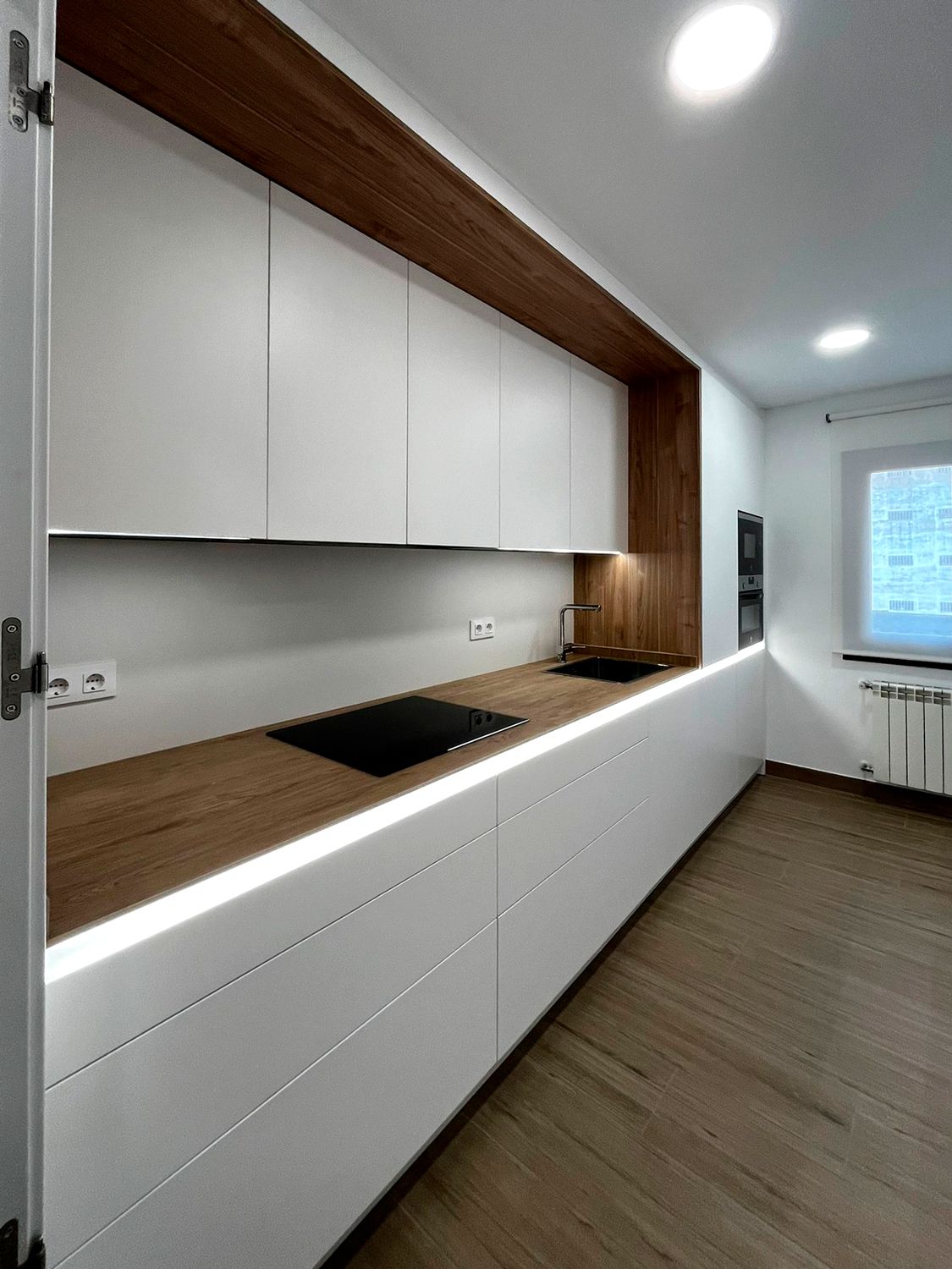 Cocina lineal blanca con madera natural y estilo minimalista – Soinco