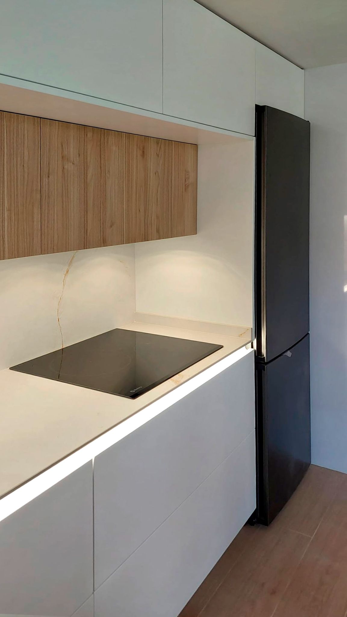 Cocina minimalista blanca con madera y encimera porcelánica Soinco
