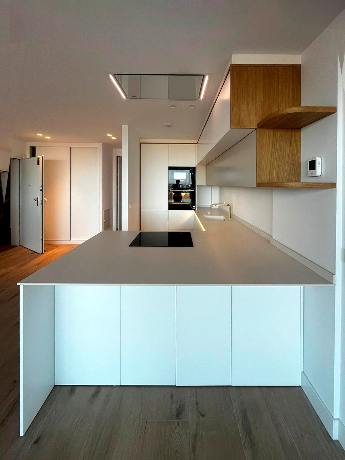 Cocina blanca con isla y detalles en madera natural