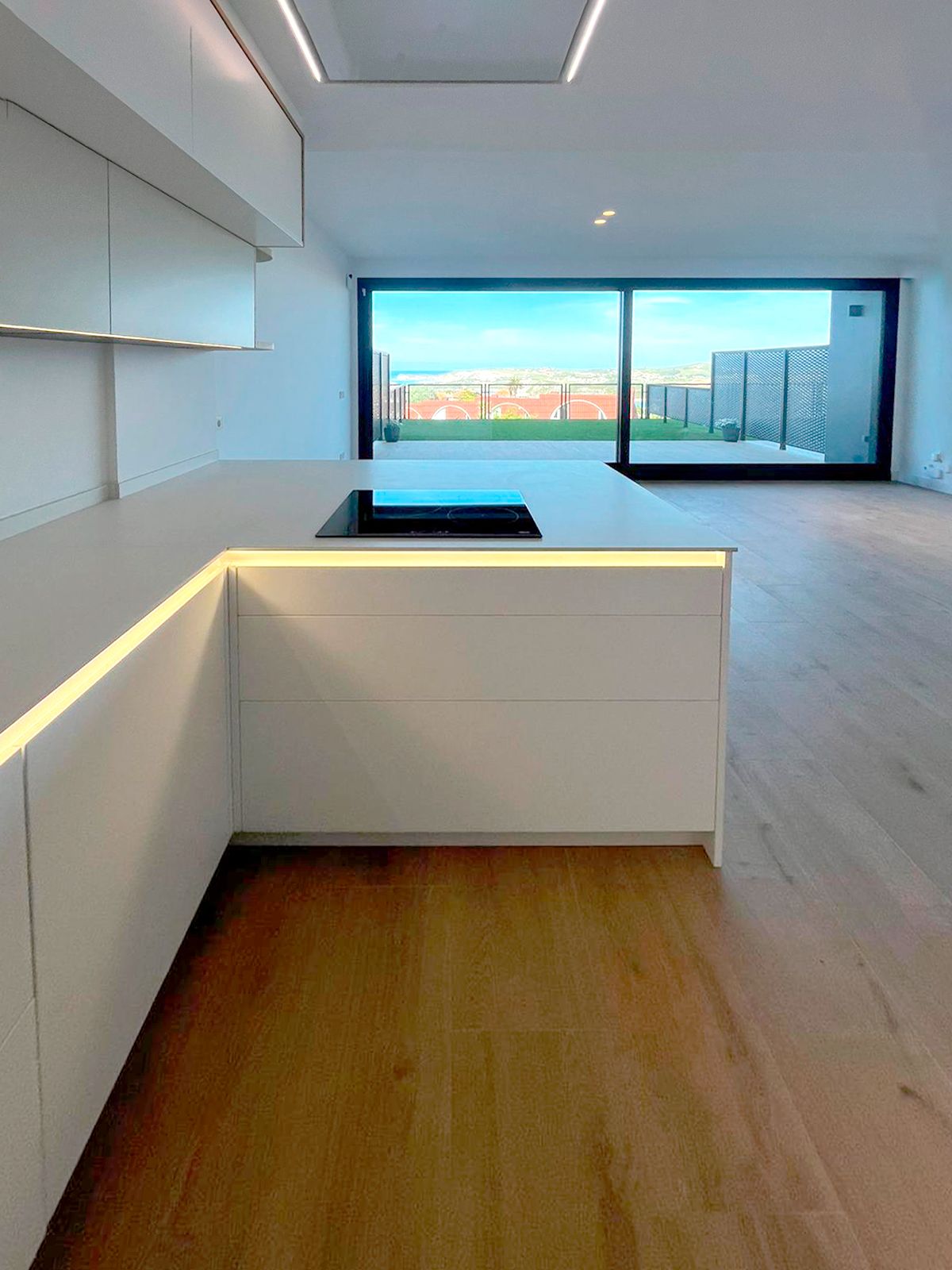 Cocina blanca abierta al salón con iluminación natural