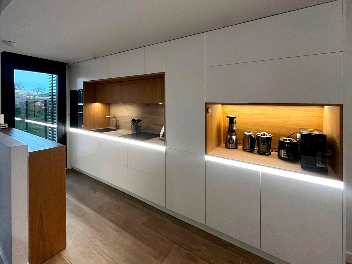 Cocina blanca con madera natural y luz LED cálida