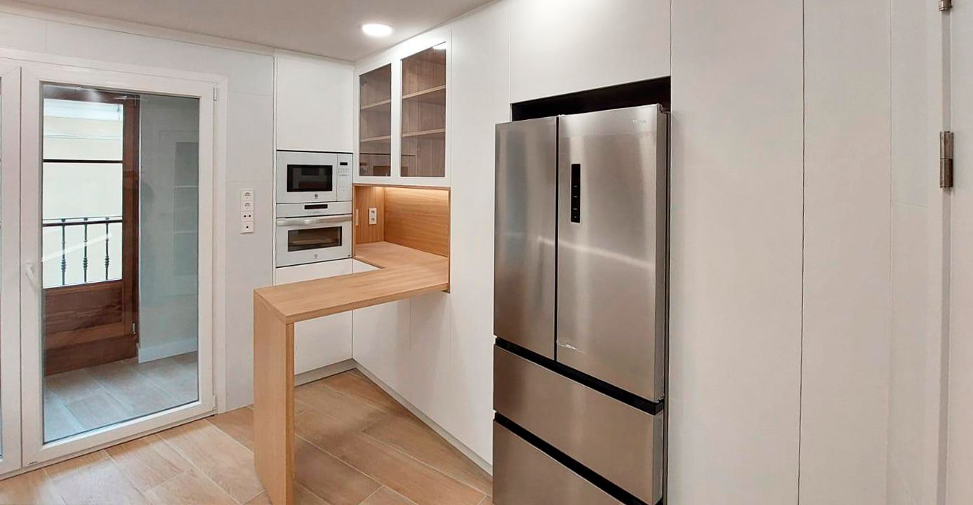 Detalle de cocina blanca y madera con electrodomésticos integrados