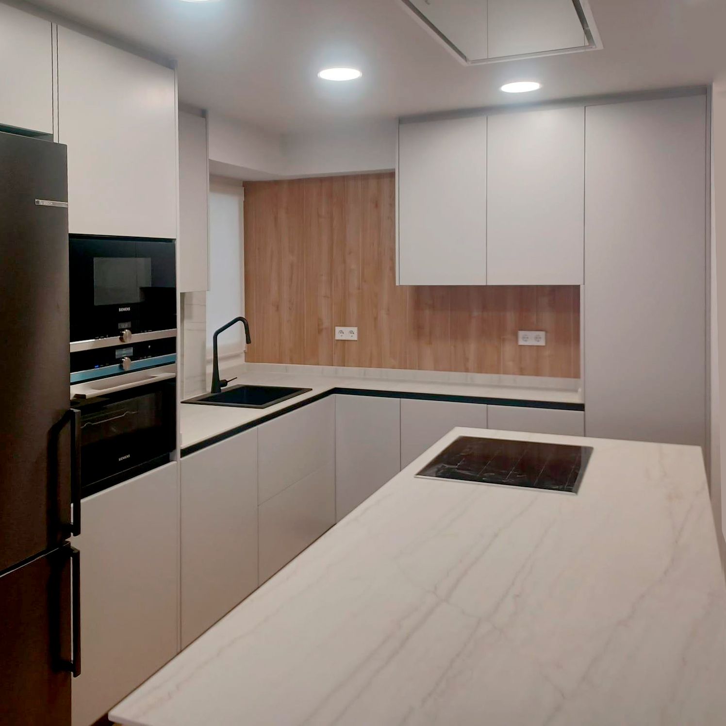 Cocina blanca moderna con isla central y encimera porcelánica Soinco