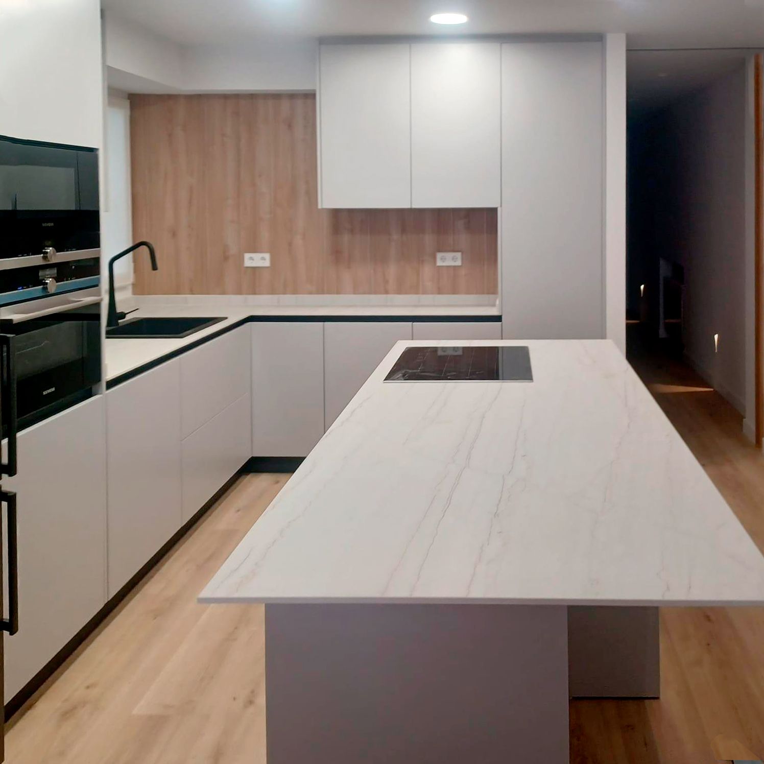 Cocina blanca moderna con isla central y encimera porcelánica Soinco