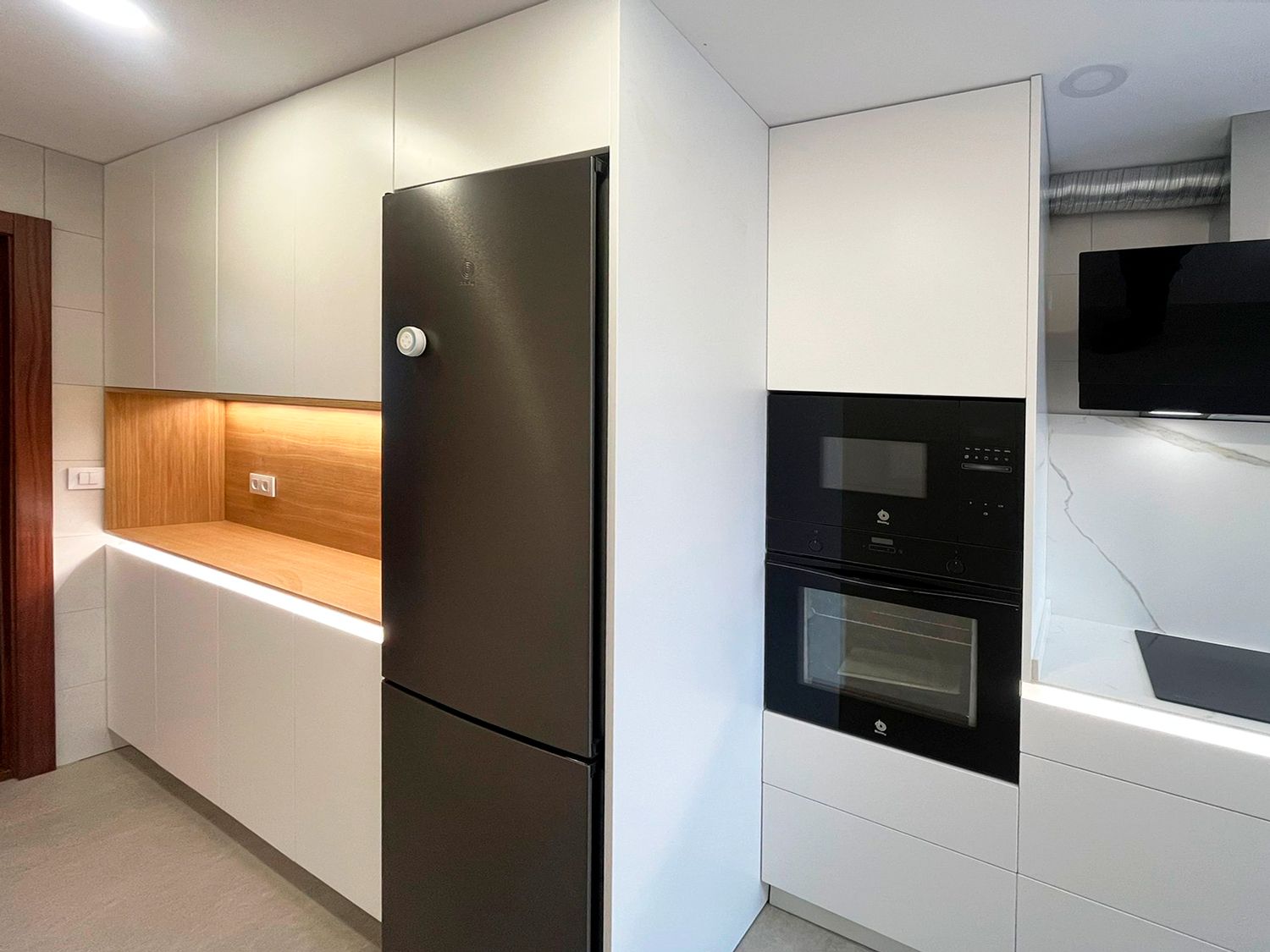 Detalle cálido en madera en cocina blanca moderna – Soinco