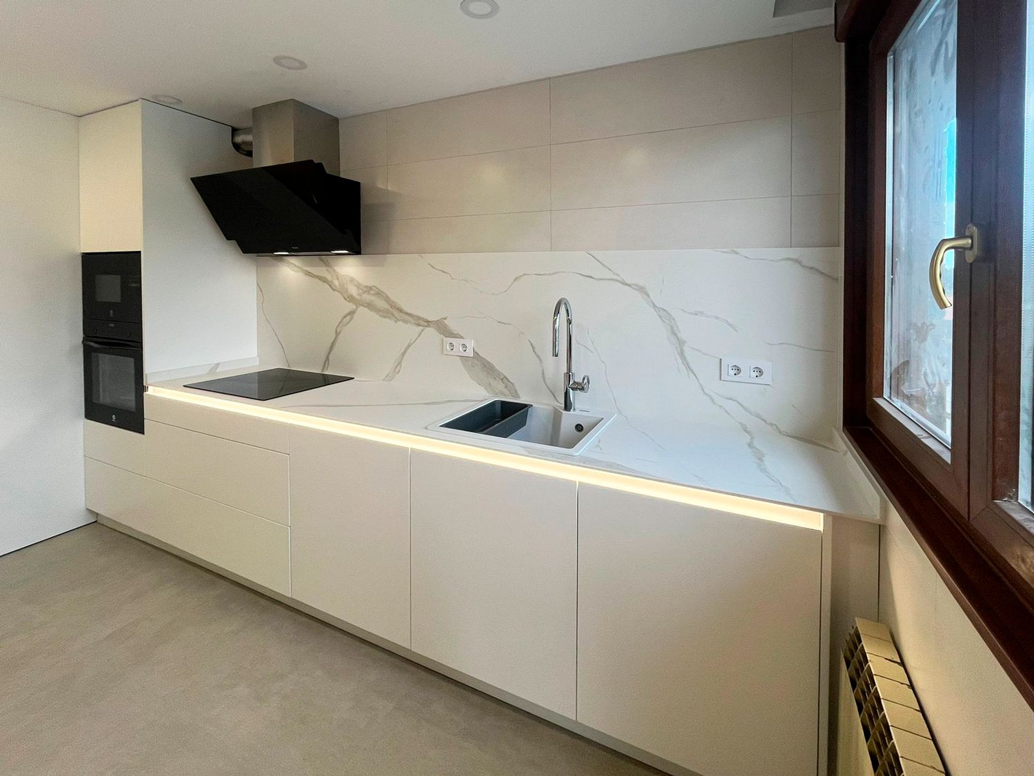 Cocina blanca con encimera efecto mármol y luz LED Soinco