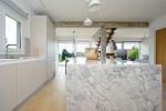 Cocina con isla de marmol gris y mobiliario minimalista