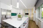Cocina con isla blanca y suelo de madera natural