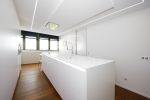 Cocina minimalista blanca con isla central y diseño moderno de Soinco
