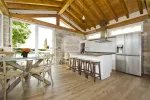 Cocina rústica moderna con salida directa al jardín y techos de madera