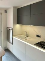 Cocina moderna en blanco y gris con madera y encimera porcelánica Soinco