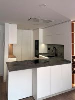 Cocina blanca con península y encimera gris piedra