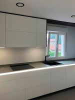 Cocina blanca con grifo negro y encimera gris