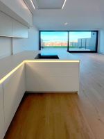 Cocina blanca abierta al salón con iluminación natural