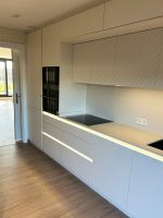 Muebles de cocina columna con integración de electrodomésticos y almacenamiento vertical en Cantabria.