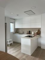 Cocina blanca con península y mobiliario a medida en Cantabria