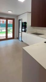 Cocina blanca moderna con detalles en nogal y electrodomésticos integrados