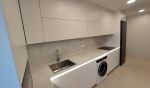 Vista general de cocina blanca lineal moderna con gran capacidad de almacenamiento