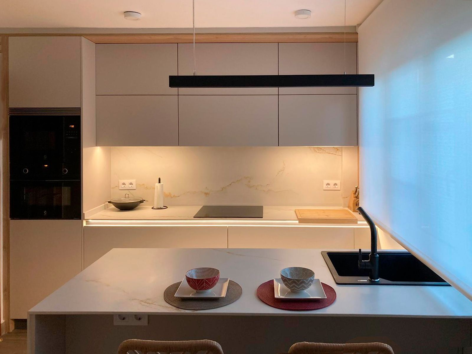 Cocina blanca con encimera de mármol y toques en madera diseñada por Soinco