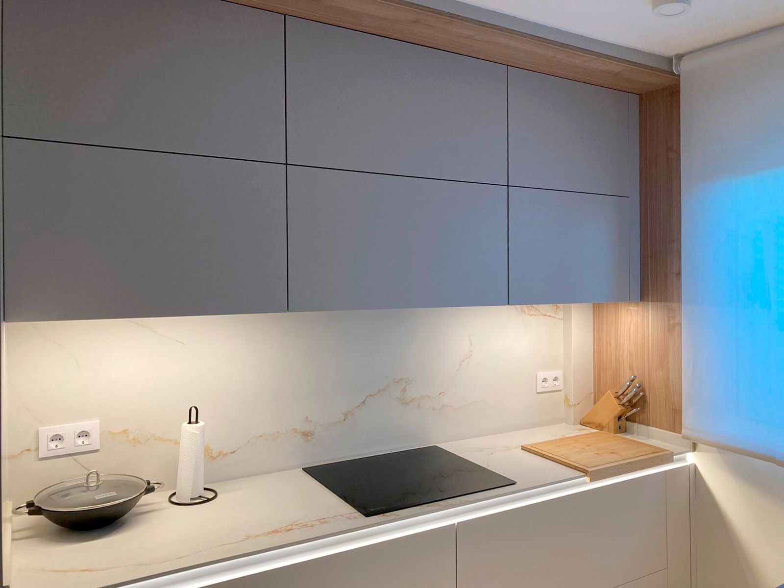 Cocina blanca con encimera de mármol y toques en madera diseñada por Soinco