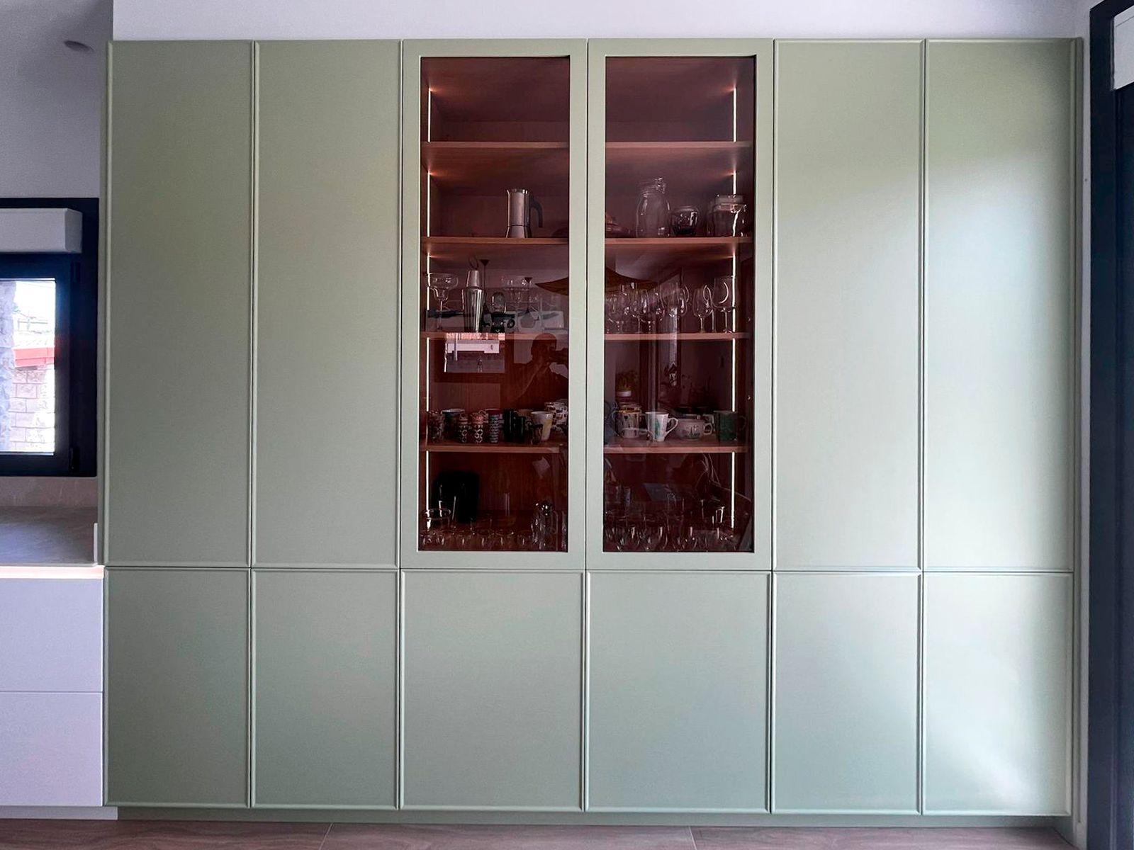 Vitrina verde iluminada en cocina moderna