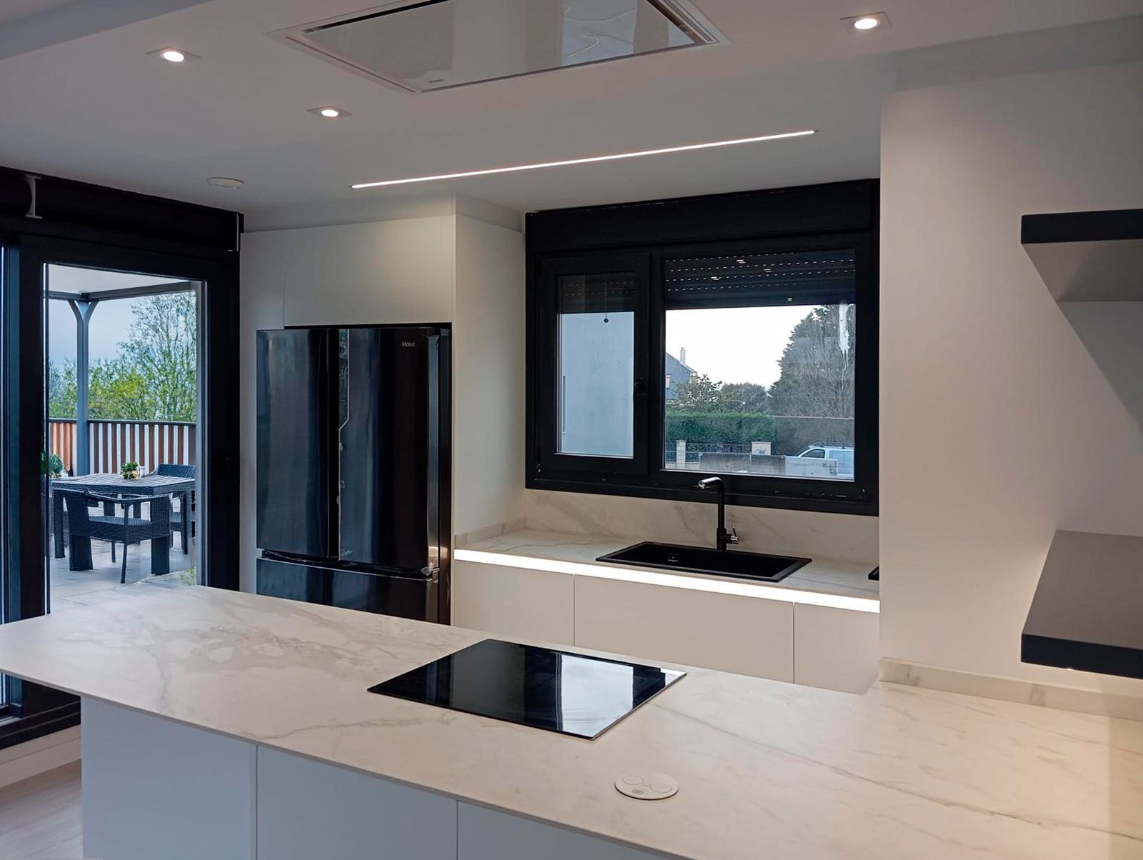 Cocina blanca con encimera efecto mármol e iluminación LED integrada