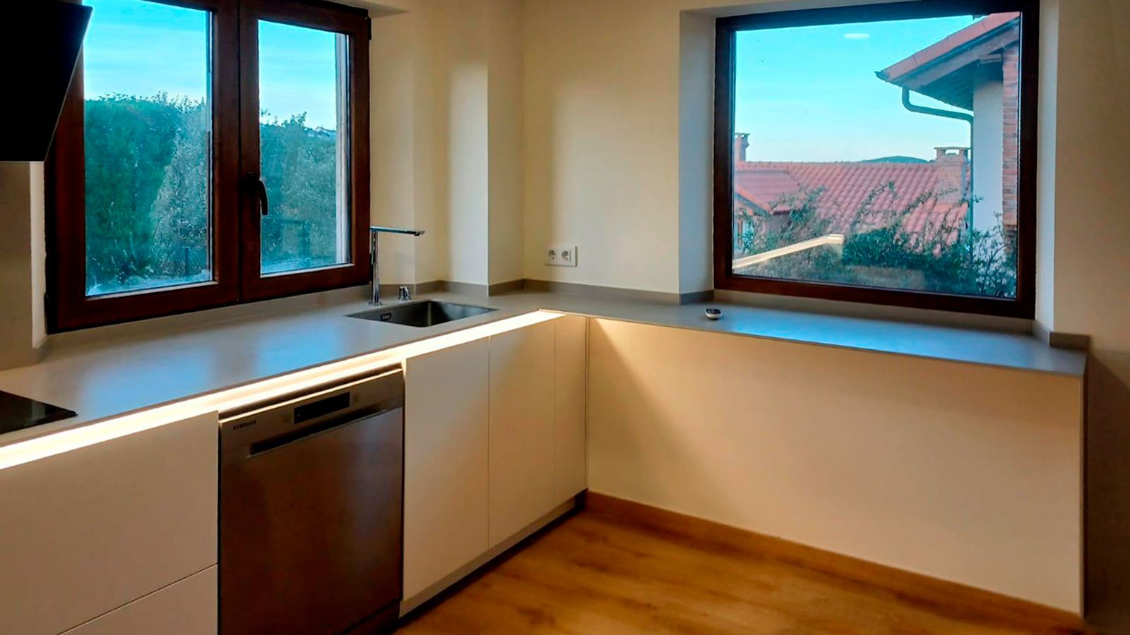 Cocina moderna blanca con madera y ventanales amplios Soinco