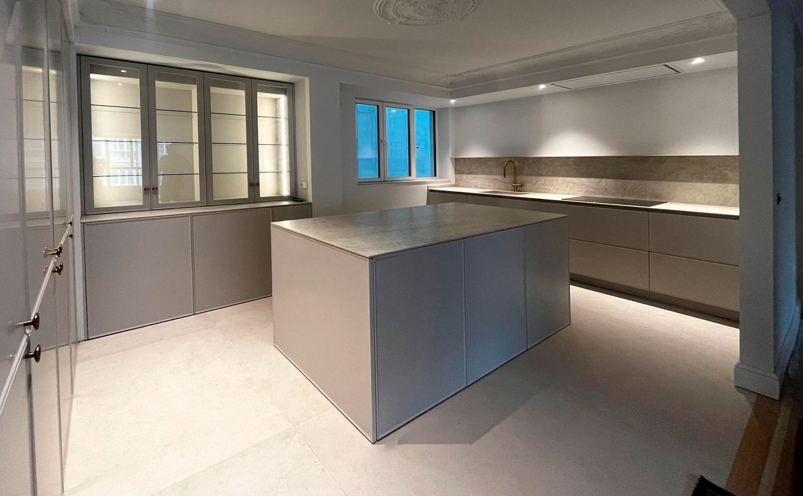 Cocina gris con isla central y encimera porcelánica