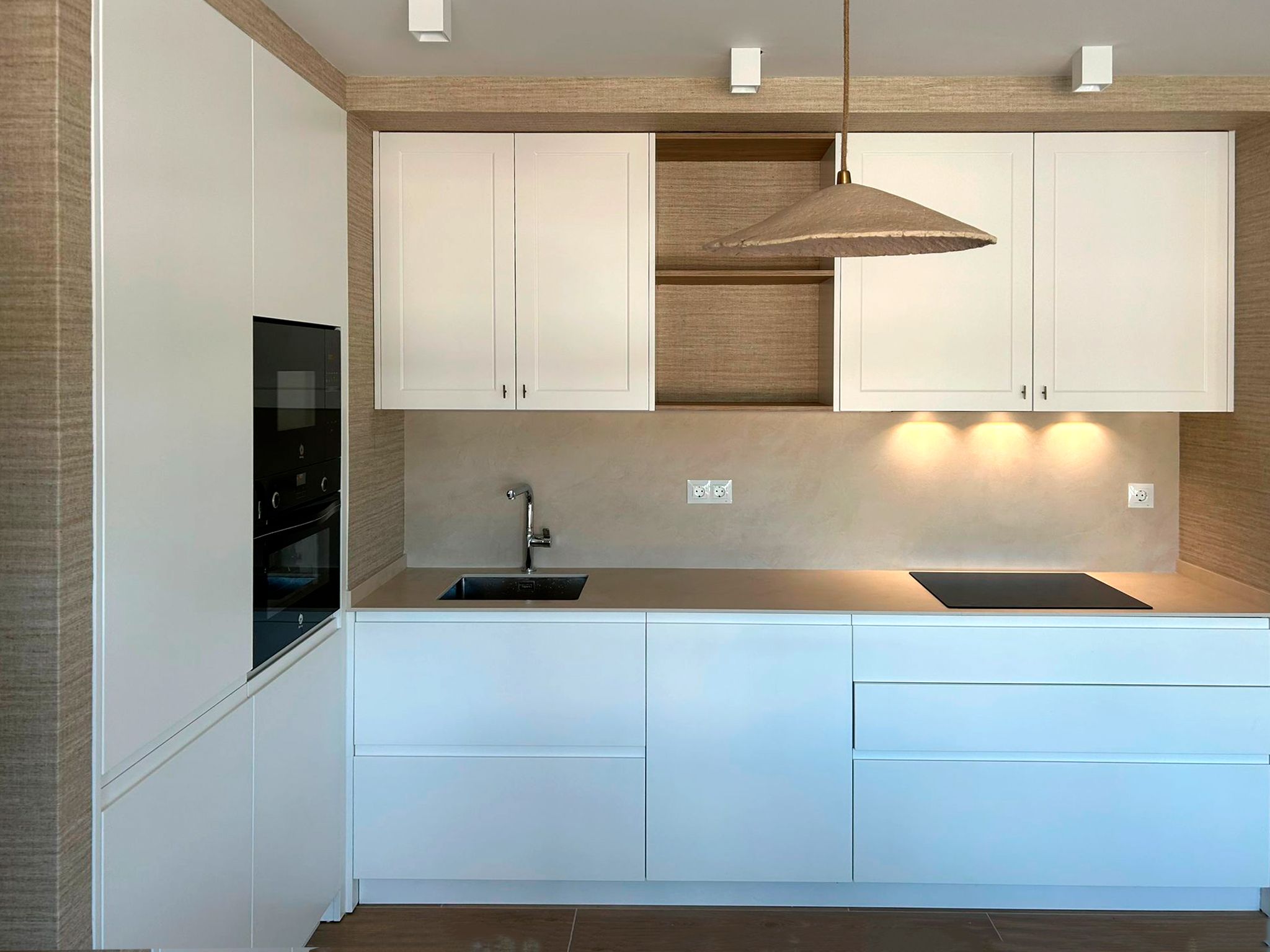 Cocina blanca con encimera beige y acabados naturales diseñada por Soinco