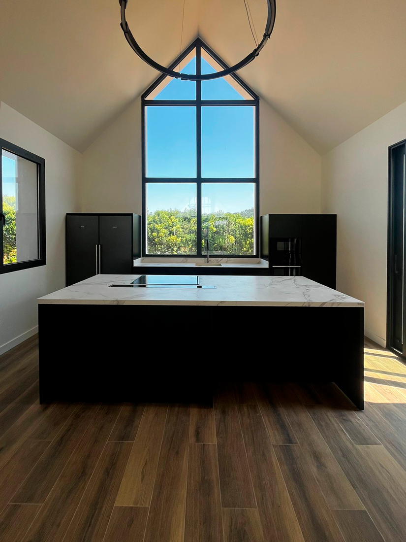 Cocina negra moderna con isla y campana de encimera integrada